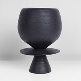 A black stoneware cup on stand with central disk made by Hans Coper in 1965 sold at auction by Maak Contemporary Ceramics