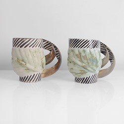 Two cream and green earthenware mugs made by Carol McNicoll in circa 1998 sold at auction by Maak Contemporary Ceramics