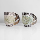 Two cream and green earthenware mugs made by Carol McNicoll in circa 1998 sold at auction by Maak Contemporary Ceramics
