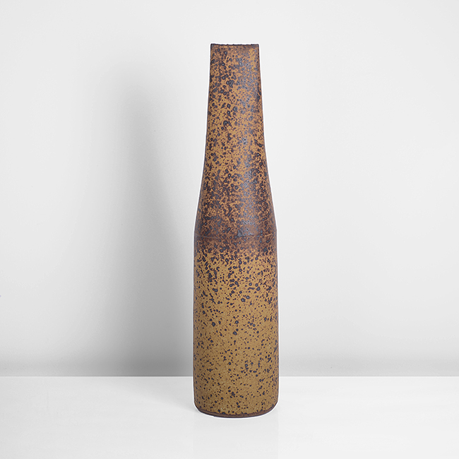 A mottled ochre and brown stoneware tapering bottle made by Joanna Constantinidis in circa 1974 sold at auction by Maak Contemporary Ceramics