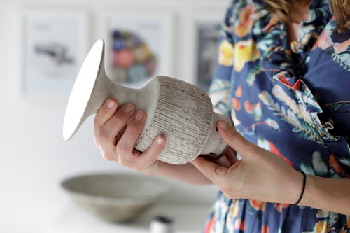 Marijke Varrall-Jones, Director of Maak Contemporary Ceramics studying a Lucie Rie Vase